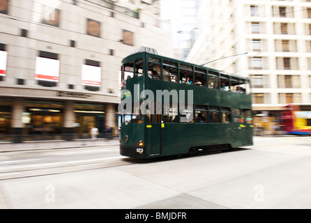 Un vecchio stile double decker bus che si muove attraverso il centro di Hong Kong, il motore diesel sono convertiti per funzionare su elettricità. Foto Stock