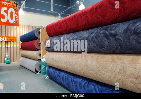 Grandi rotoli di tappeti sul display in Allied Carpets. Circa il 50% di sconto. Foto Stock