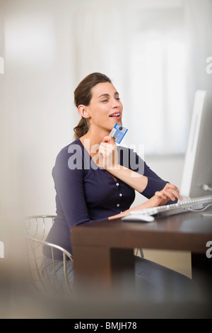 Donna incinta facendo shopping online Foto Stock