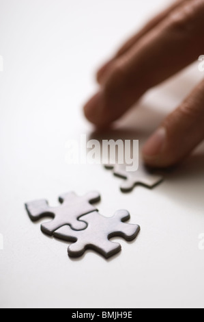 Mano umana unire pezzi di puzzle, close-up Foto Stock