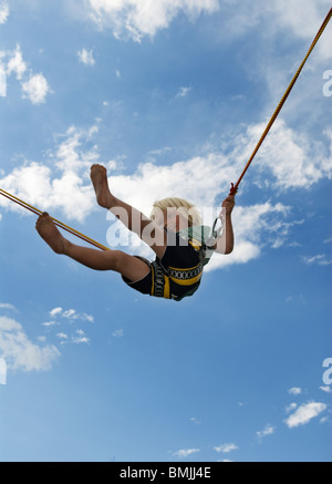 La Scandinavia, Svezia, Ostergotland, Linkoping, ragazzo giocando su bungee jumping, basso angolo di visione Foto Stock