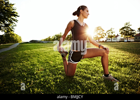 Giovane donna facendo esercizi di stretching all'aperto, Svezia. Foto Stock