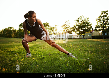 Giovane donna facendo esercizi di stretching all'aperto, Svezia. Foto Stock