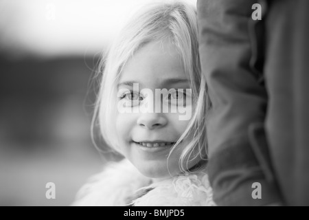La Scandinavia, Svezia, Vastergotland, ragazza in piedi con padre, sorridente, close-up Foto Stock