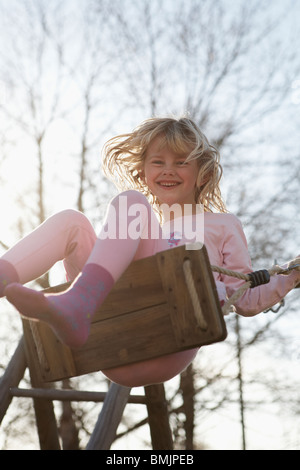 La Scandinavia, Svezia, Vastergotland, ragazza su swing, sorridente Foto Stock