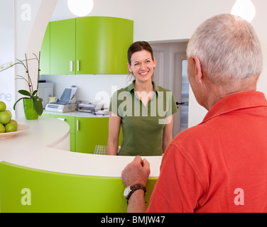 Receptionist con paziente in chirurgia Foto Stock