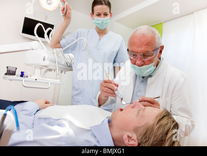 Dentista con paziente in chirurgia Foto Stock