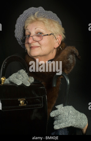 Un anziano, molto elegante e vecchia signora vestita con un molto sly, smart e atteggiamento giocoso Foto Stock