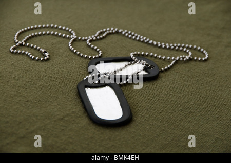 Dog tags militari e la catena sul green tee shirt sfondo. Foto Stock