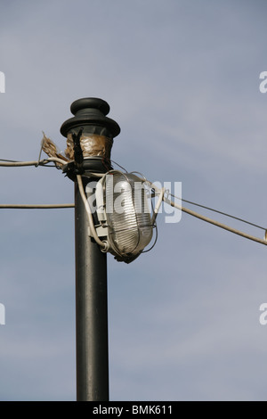 Danneggiato street lampada posta all'aperto in sun Foto Stock