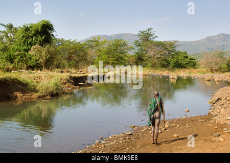 Africa, Etiopia, regione dell'Omo, Kibish. Suri boy attraversa il fiume. Foto Stock