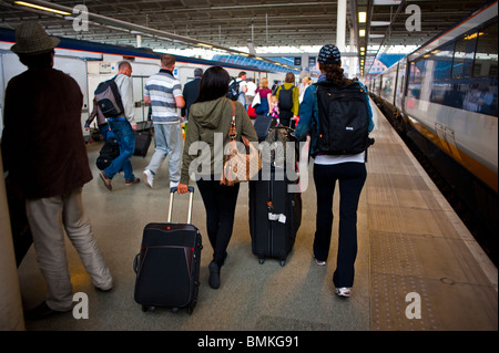 Londra, Inghilterra, Regno Unito, Gran Bretagna, una folla di giovani turisti che viaggiano nella stazione ferroviaria ad alta velocità, St Pancras, Eurostar, Woman Walking Away, Crowd From Rear, con valigie Foto Stock