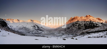 Alba la luce del sole su The Langdale Pikes, Bowfell e Crinkle Crags in inverno, Lake District inglese Foto Stock