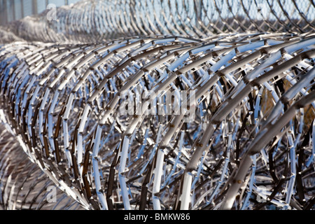 Rulli di acciaio inossidabile filo spinato spirali tenere prigionieri lontano dalla catena di recinzione di collegamento alla struttura di correzzione in Florida Foto Stock