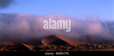 La Namibia, Namib Nauklift National Park, nebbia mattutina rotoli in dall Oceano Atlantico oltre le dune di sabbia a Sossusvlei Foto Stock