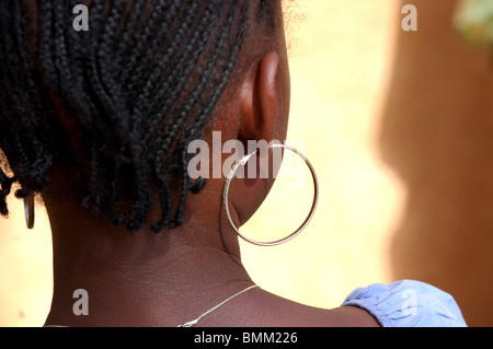 Niger, Niamey, trecce e grande cerchio orecchini in argento di una ragazza africana, visto dal retro. Foto Stock