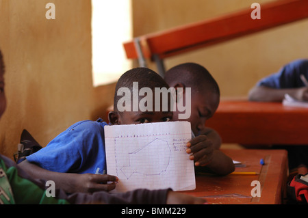 Niger, Niamey, gli studenti africani seduti alla scrivania di legno in aula. Foto Stock