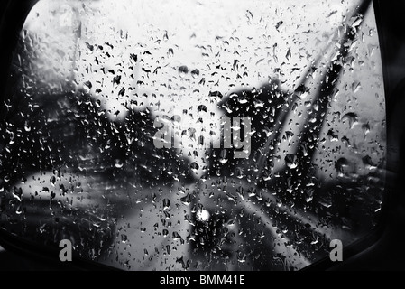 Le gocce di pioggia della specchio auto su una solitaria grigia giornata piovosa. Foto Stock