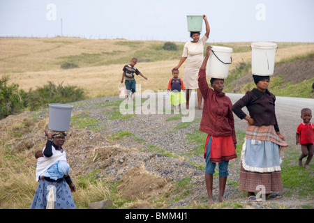 Transkye, Sud Africa. Esempi di cultura tradizionale africana come le donne che trasportano oggetti pesanti sulle loro teste. Foto Stock