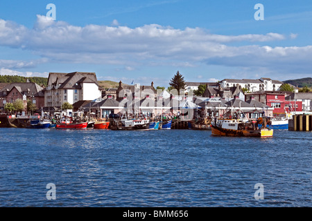 Una barca da pesca è in arrivo nel porto di Oban Lorn Scozia con altre barche già ormeggiate lungo il molo. Foto Stock