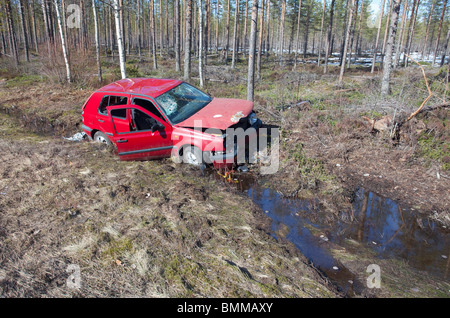 Crash Volkswagen golf rosso VW posa a bordo strada fossato, Finlandia Foto Stock