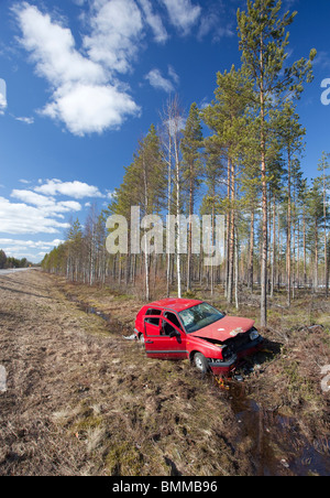 Si è schiantato il VW Volkswagen Golf rosso giacendo nel fosso finlandese sulla strada di campagna, Finlandia Foto Stock