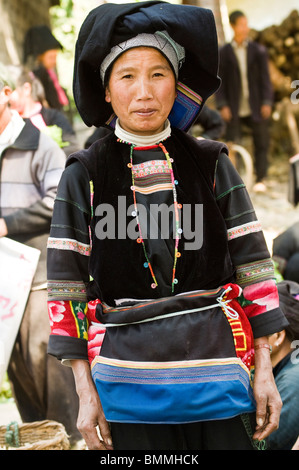 Una donna tribale in un mercato locale in Yunnan. Foto Stock