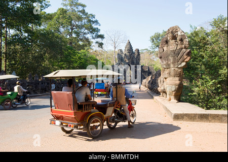 Motociclo tuk tuks dal naga statue e Porta Vittoria vicino all'entrata sud di Angkor Thom Foto Stock