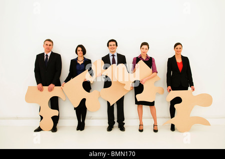 Gruppo di lavoratori attesa pezzi di puzzle Foto Stock