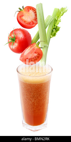 Fette di pomodoro e il sedano di cadere in un bicchiere di succo di frutta fresco Foto Stock