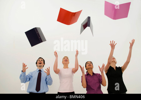 Esultante la gente di affari di gettare le cartelle Foto Stock