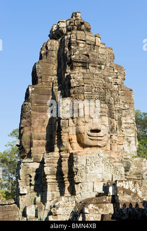 Uno dei molti pietra intagliata rivolta al Tempio di Bayon ad Angkor Thom, Cambogia Foto Stock