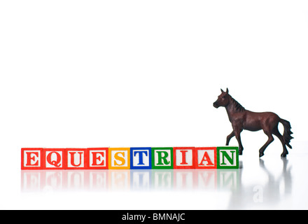 Bambini colorati i blocchi equestre di ortografia con un cavallo in background Foto Stock