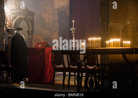 Sacerdote pregare in una chiesa ortodossa in Armenia. Foto Stock