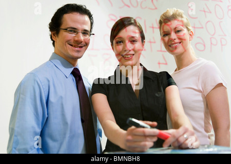 Tre le persone felici di sostare dietro il vetro Foto Stock