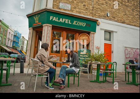 Londra, Inghilterra, Regno Unito, 2 donne che mangiano fuori dal fast food "Falafel King", in Portobello Road, Notting Hill District Foto Stock