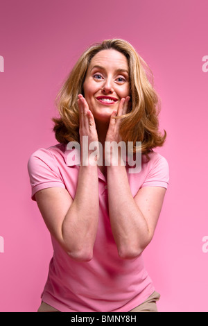 Il piacere della donna in abbigliamento casual su sfondo rosa Foto Stock