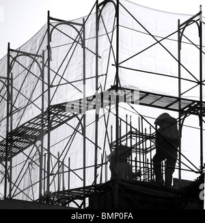 Tubi in acciaio, scale e reti di sicurezza sono usati come impalcature Foto Stock