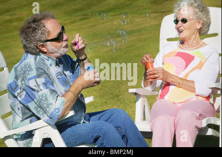 Sherwood Park, Alberta, Canada; un paio di soffiare bolle seduti a sdraio Foto Stock