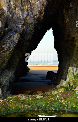 Grotta passaggio su tre Cliffs Bay, Penisola di Gower, South West Wales. Arco di mare Foto Stock