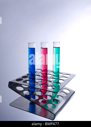 Tre provette riempite con liquidi colorati su una rastrelliera metallica. Foto Stock