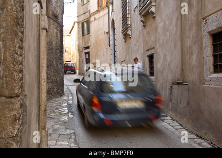 Veicoli auto strette stradine pedonali mentre controlla il traffico edifici, nella storica città di Amelia, Umbria, Italia Foto Stock