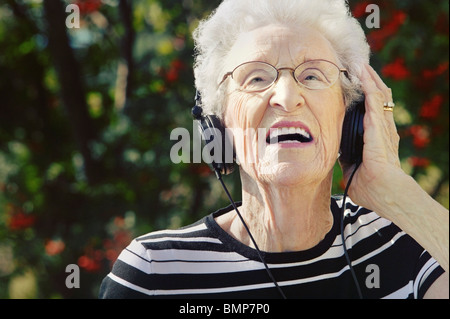 Sherwood Park, Alberta, Canada; un Senior donna che indossa le cuffie Foto Stock