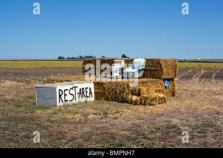 Un'area di riposo divertente è una satira nei pressi di Alliance, Nebraska: Un bagno arroccato su balle di fieno in una remota fattoria, un'attrazione stravagante a lato della strada. Foto Stock