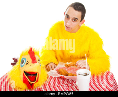 Teen boy con acne in costume di pollo mangiare alimenti fritti. Sfondo bianco. Foto Stock