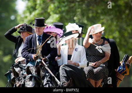 Frequentatori di gara arriva con il carro trainato da cavalli per il Royal Ascot gara incontro di indossare cappelli Foto Stock