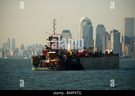 Il Barney Turecamo rimorchiatore si muove una chiatta laden con carico in New York e nel New Jersey Harbour Foto Stock