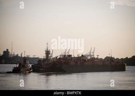 Rimorchiatori entrando in Newark Bay si muovono chiatte laden con carico in New York e nel New Jersey Harbour Foto Stock