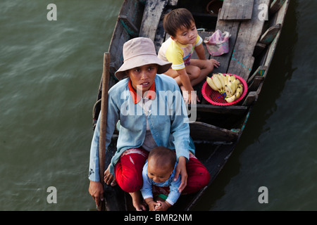 Commerciante donna con i suoi figli in una barca vicino a Siem Reap Foto Stock