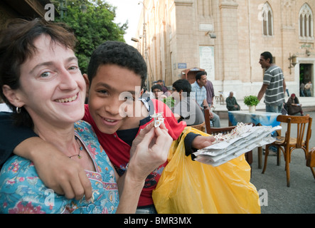 Un giovane ragazzo egiziano amicizie con un turista occidentale per cercare di vendere la sua mercanzia, il quartiere islamico, al Cairo in Egitto Foto Stock